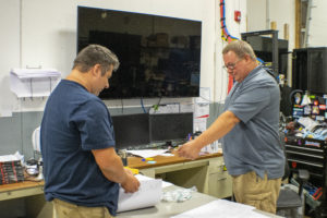 Mike Glass and Chris Plym collaborating on AV project planning at RoomReady